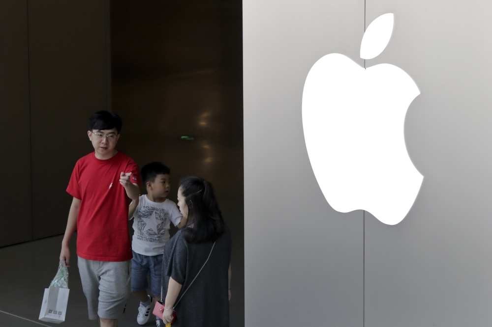 A Chinese family walks out of an Apple store in Beijing, Sunday. China appears to have succeeded in eliminating software programs that enable its people to view an uncensored Internet. Companies that let people avoid the government filters said Saturday their programs have been removed from Apple's app store in China. — AP