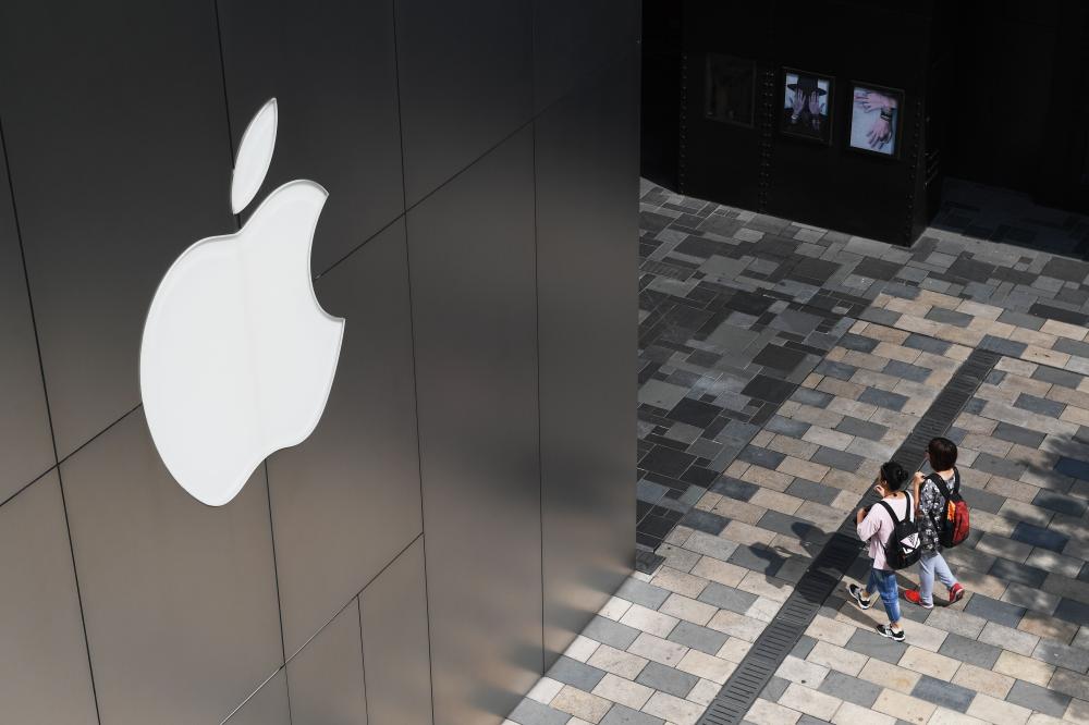 People walk past an Apple store in Beijing in this file photo. — AFP