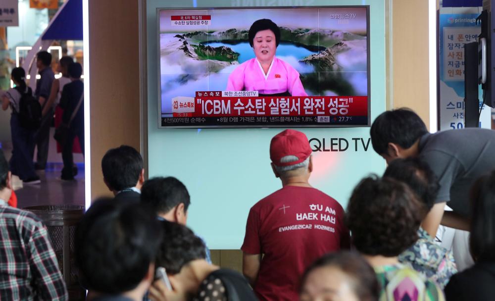 People watch a TV news report about North Korea's  hydrogen bomb test at a railway station in Seoul, South Korea on Sunday. — Reuters
