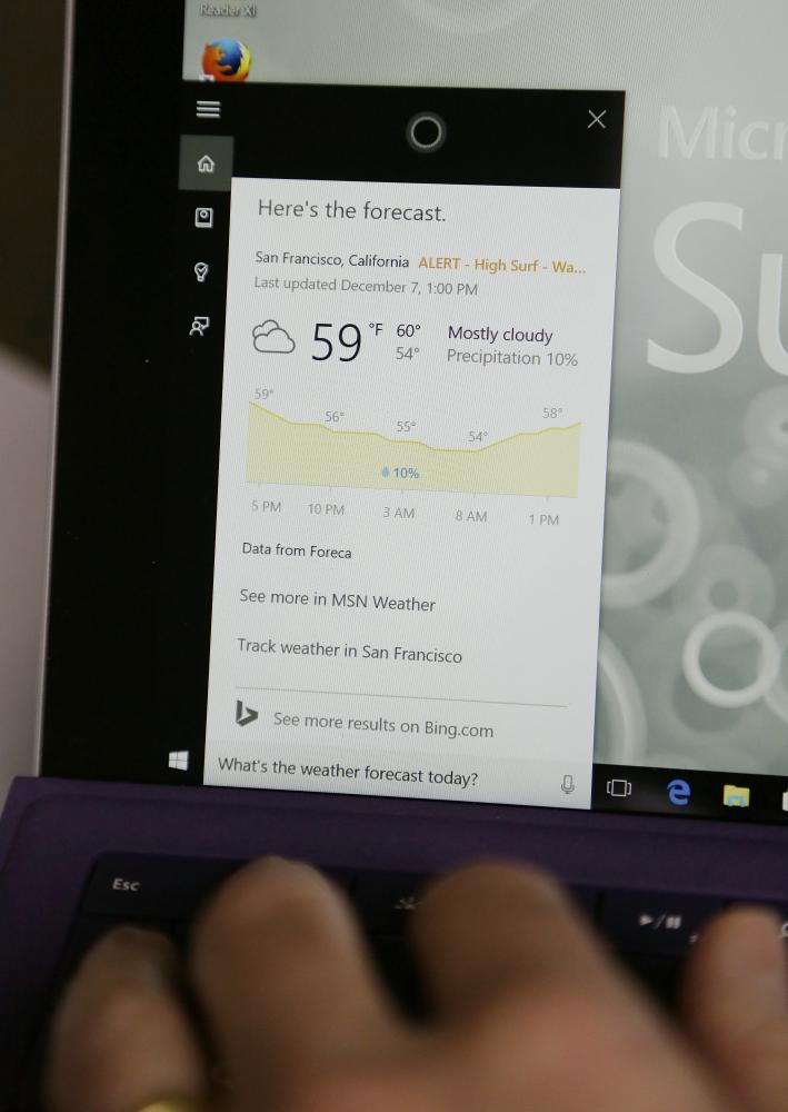 In this file photo, Associated Press technology writer Brandon Bailey uses the Cortana digital assistant to get the weather forecast in San Francisco. Microsoft and Amazon are making their Alexa and Cortana voice assistants team up and talk to each other in a new collaboration. — AP