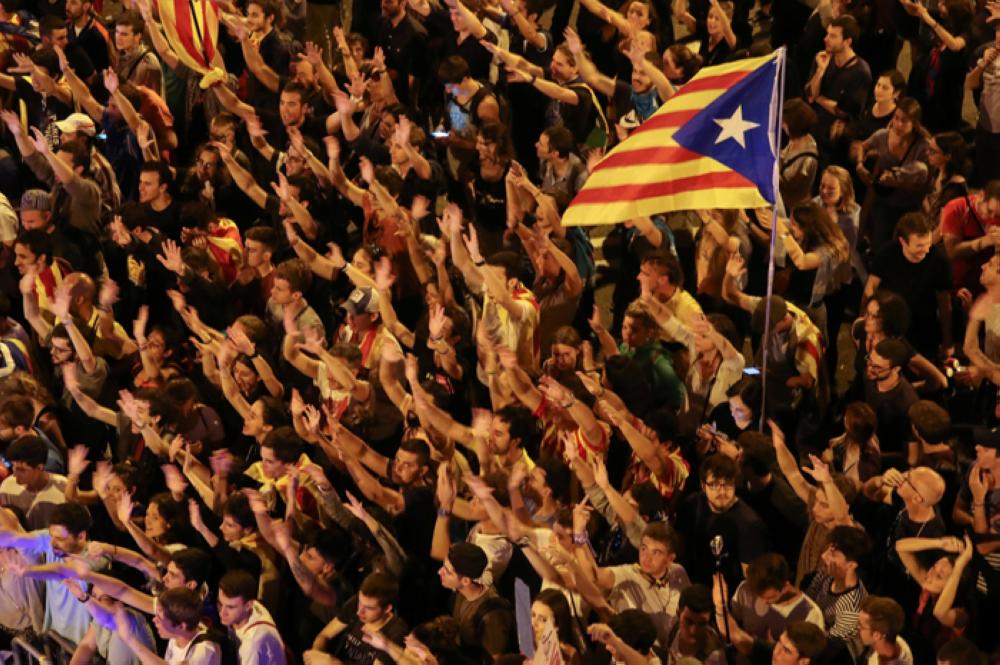 People raise arms and shout during a demonstration two days after the banned independence referendum in Barcelona Spain on Tuesday.
