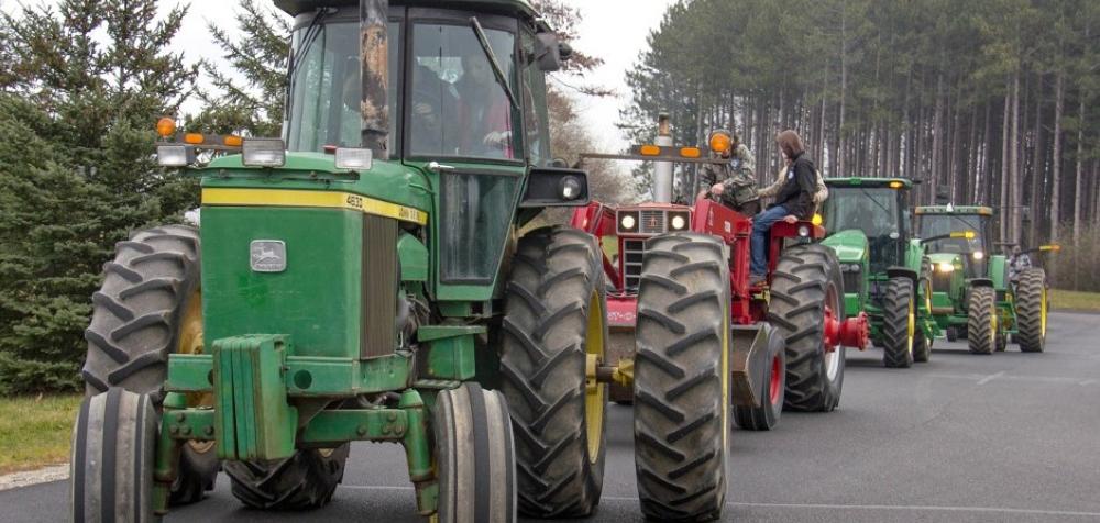 High school students line up their tractors at the entryway to Central Montcalm Upper Elementary before parading in front of the student body at the school for Drive Your Tractor to School Day.