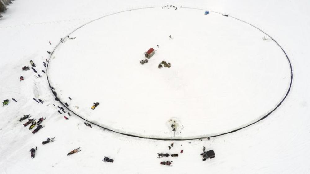 A massive ice carousel that's 130 meters in diameter is seen on Sunday on a frozen lake in Sinclair, Maine. Volunteers say it’s large enough to beat the old record held by a town in Finland; four outboard engines were used to make it rotate. - AP