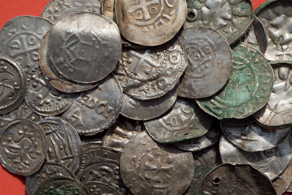 Saxon, Ottonian, Danish and Byzantine coins recovered from a treasure trove are pictured on a table in Schaprode, northern Germany on Monday. - AFP