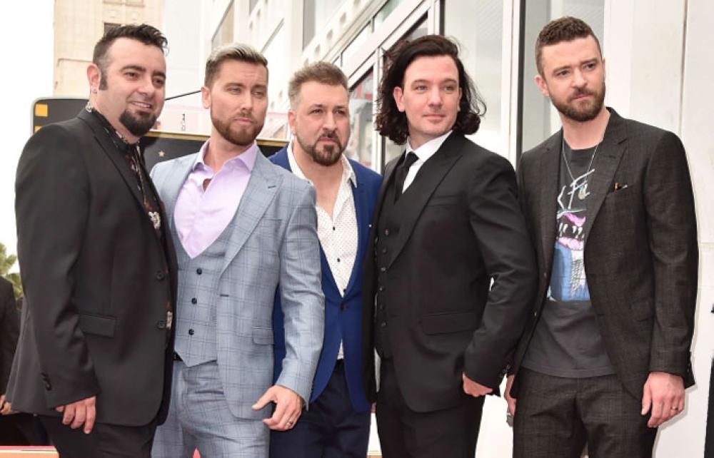 From left, members of the iconic 90's boyband NSYNC, Chris Kirkpatrick, Lance Bass, JC Chasez, Joey Fatone and Justin Timberlake pose as they are honored with a star on the Hollywood Walk of Fame in Hollywood, California on Tuesday. - AFP