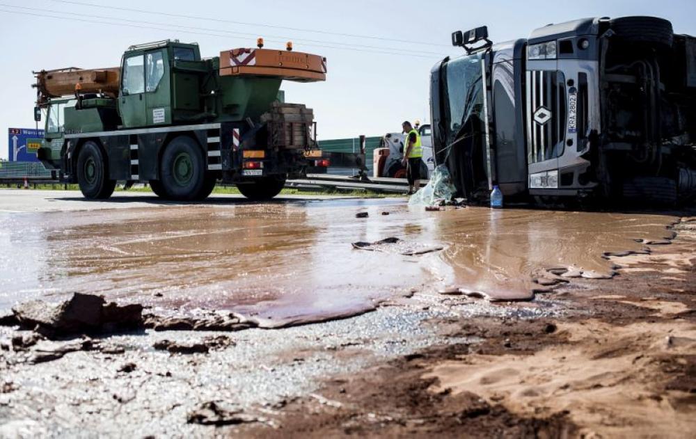 Tons of liquid milk chocolate are spilled and block six lanes on a highway after a truck transporting it overturned near Slupca, in western Poland, on Wednesday. - AP