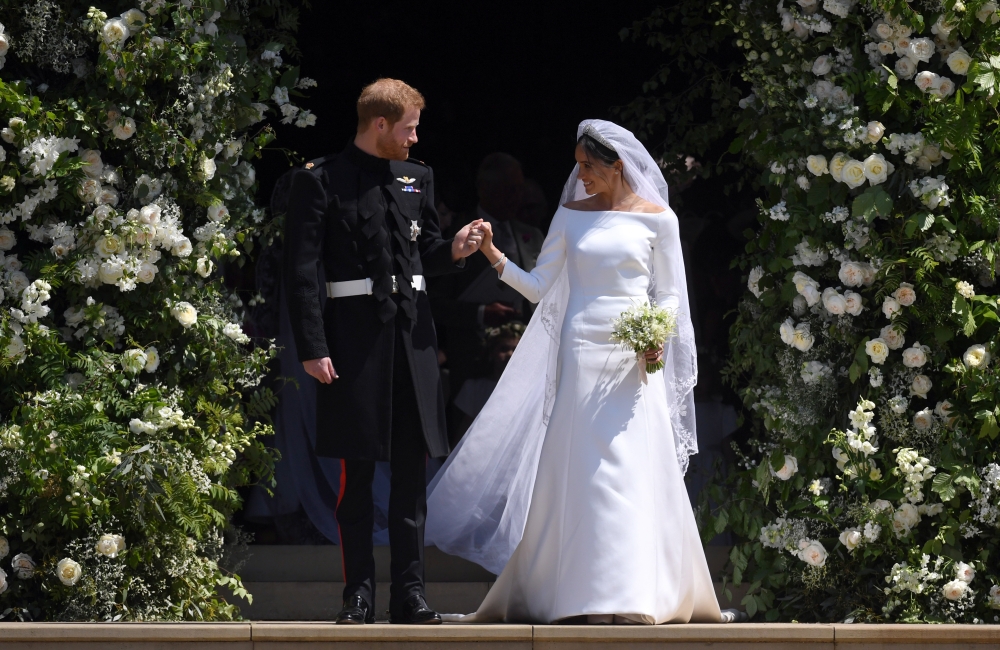 Britain's Prince Harry, Duke of Sussex and Meghan, Duchess of Sussex exit St George's Chapel in Windsor Castle after their royal wedding ceremony, in Windsor on Saturday. - EPA
