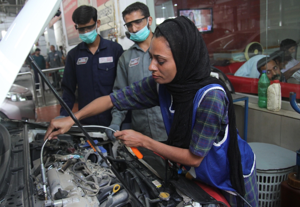 Pakistani motor mechanic Uzma Nawaz, 24, fixes a car at an auto workshop in Multan.  Since picking up a wrench as one of the first female car mechanics in conservative Pakistan, Uzma Nawaz has faced two common reactions: shock and surprise. And then a bit of respect. —AFP