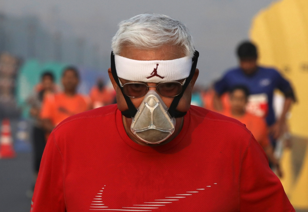 


A runner wearing a face mask for protection from air pollution takes part in the Delhi Half Marathon in New Delhi on Sunday. — Reuters
