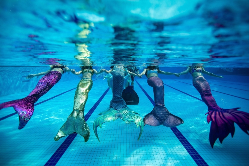 Swimmers (L to R) twin sisters Teo Jia Yin and Teo Jia Qin, Naomi Wong Jiag, Koh Yi Xuen and Chan Yushi performing, wearing mermaid tails, in a swimming pool in Klang, on the outskirts of Kuala Lumpur. — AFP