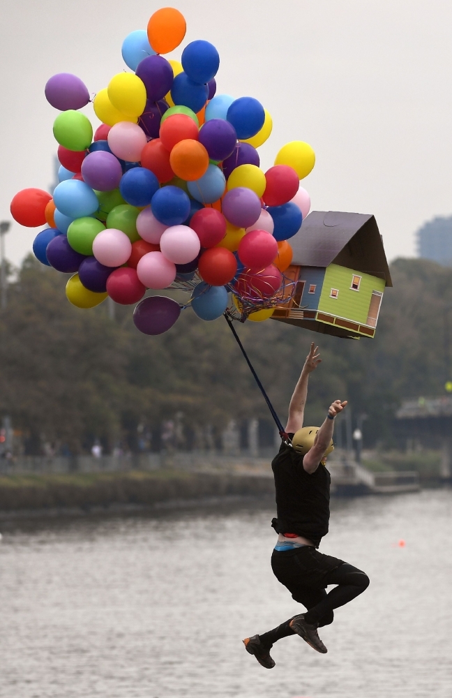 A competitor jumps into the Yarra River with his homemade flying device during the annual Birdman Rally at the Moomba Festival in Melbourne. — AFP