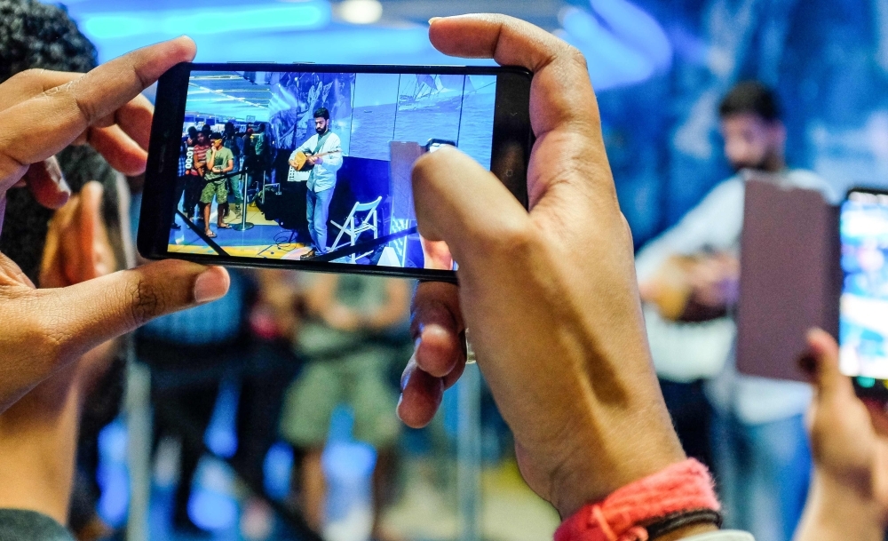A man uses his phone to film artist Omar Hamdan performing using Buzuq instrument as part of Dubai Metro Music Festival at Bur Juman Metro station in Dubai on Wednesday. — AFP