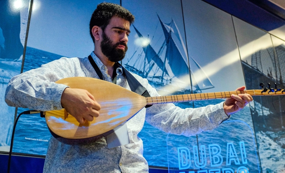 A man uses his phone to film artist Omar Hamdan performing using Buzuq instrument as part of Dubai Metro Music Festival at Bur Juman Metro station in Dubai on Wednesday. — AFP