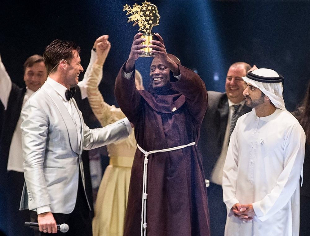 


This handout picture provided by the Global Education and Skills Forum, an initiative of the Varkey Foundation, shows Kenyan teacher Peter Tabichi (C) holding up the Global Teacher Prize (GTP) trophy after winning the US$ 1 million award during an official ceremony in Dubai presented by Australian actor Hugh Jackman (C-L) and attended by the Dubai Crown Prince Hamdan Bin Mohammed Al-Maktoum (C-R). — AFP