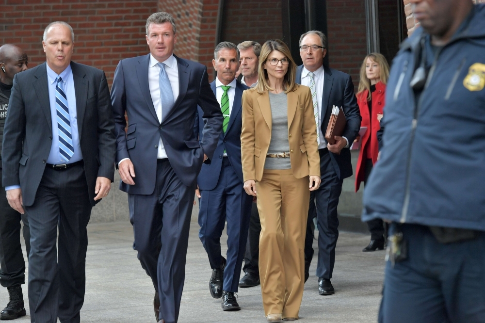 Two girls wear Lori Loughlin mask at the John Joseph Moakley United States Courthouse in Boston, Massachusetts, on Wednesday. — AFP