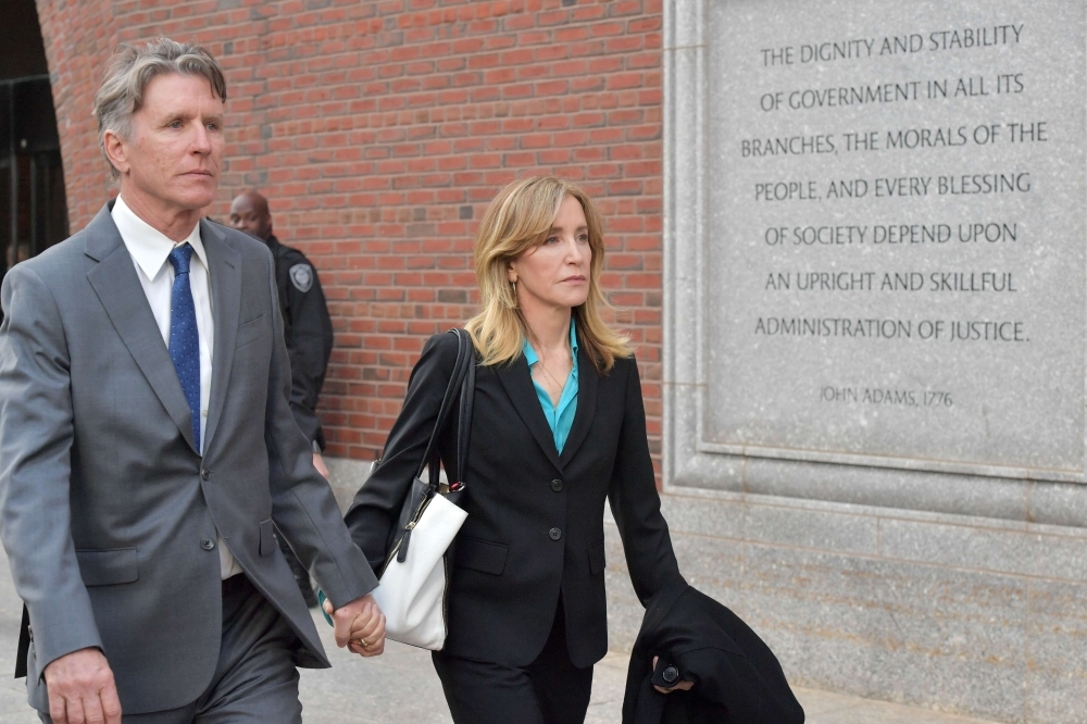 Two girls wear Lori Loughlin mask at the John Joseph Moakley United States Courthouse in Boston, Massachusetts, on Wednesday. — AFP