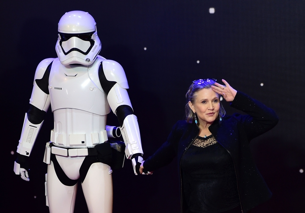 US actress Carrie Fisher poses with a storm trooper as she attends the opening of the European Premiere of 