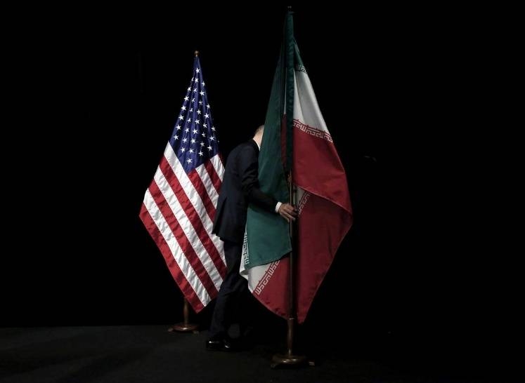 A staff member removes the Iranian flag from the stage after a group picture with foreign ministers and representatives of the US, Iran, China, Russia, Britain, Germany, France and the European Union during Iran nuclear talks at the Vienna International Center in Vienna, Austria, in this file photo. — Reuters