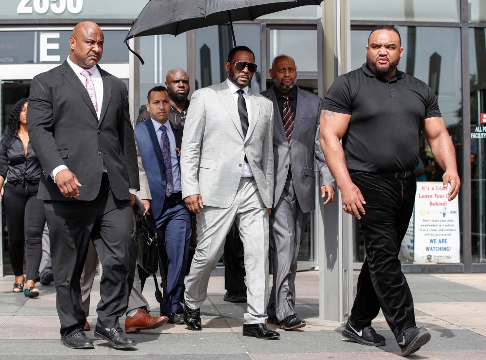 Singer R. Kelly, center, leaves the Leighton Criminal Court Building after a hearing on sexual abuse charges in Chicago, Illinois, on Thursday. — AFP