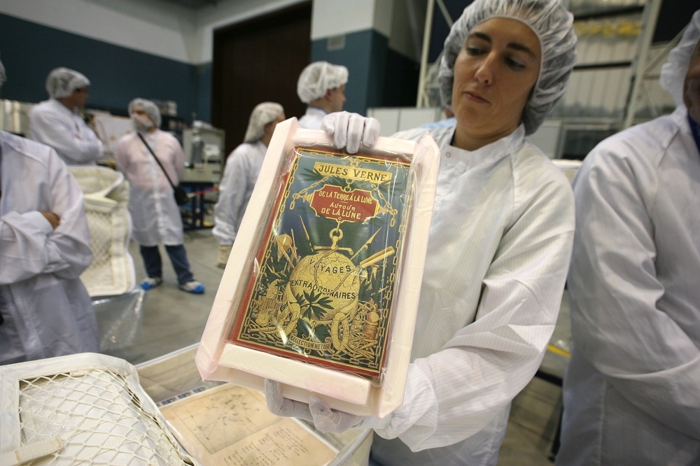 In this file photo taken on Oct. 3, 2007 a technician wraps up Jules Verne's manuscript 'From the Earth to the Moon' and 'Around the Moon' before it is sent into space with the next mission at the Thales Alenia Space center in Turin, Italy. With their landing on the Moon in 1969, the Americans Neil Armstrong and Buzz Aldrin have left a footprint that has fueled the fantasies of man for centuries and opened new horizons to artists, writers, filmmakers and so on. — AFP