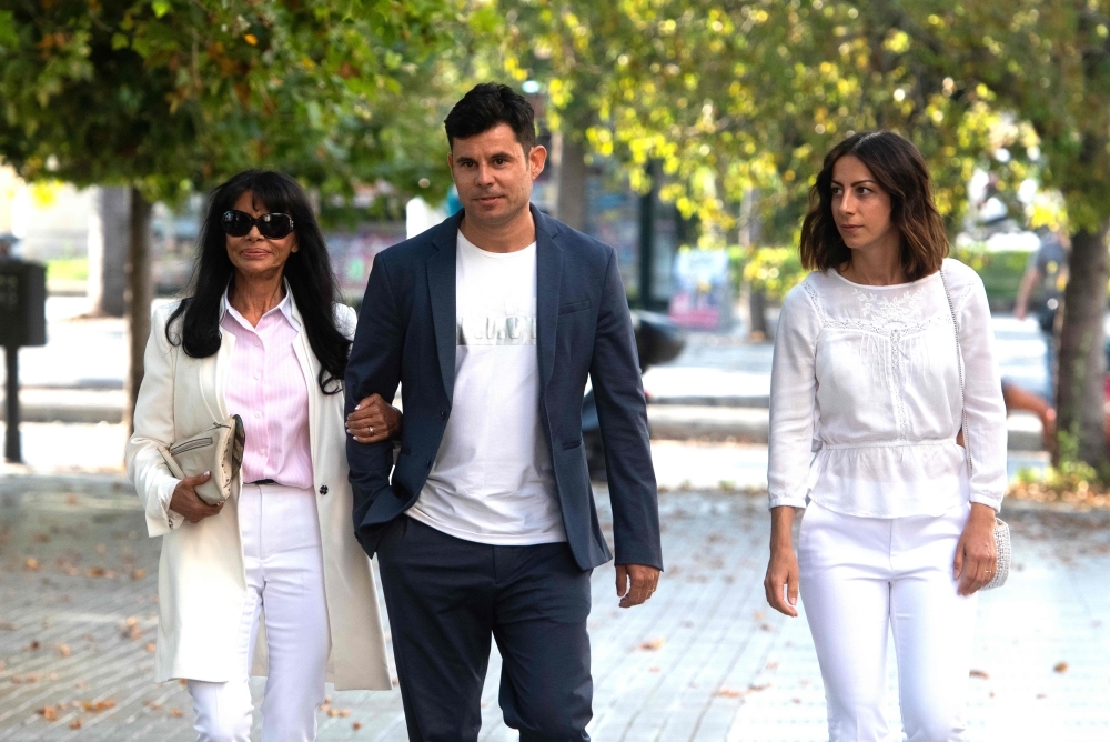 Javier Sanchez Santos, who claims to be the son of Spanish crooner Julio Iglesias, arrives with his mother Maria Edite Santos (L) and his Italian partner Chiara Allegrini (R) to appear to the court of Valencia before a hearing to examine his paternity claim on Thursday (July 4). —  AFP