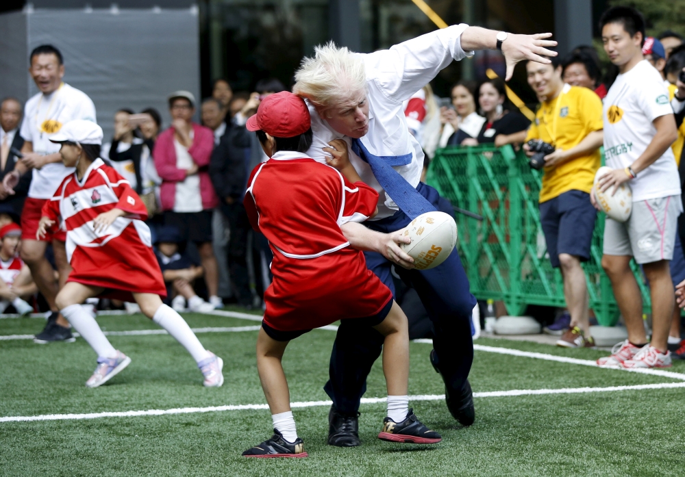 London's Mayor Boris Johnson (front R) collides with 10-year-old Toki Sekiguchi during a game of Street Rugby with a group of Tokyo children, outside the Tokyo Square Gardens building in this Oct. 15, 2015, file photo. The game was held with the attendance of school children, Nihonbashi, Yaesu and Kyobashi Community Associations and the Street Rugby Alliance to mark Japan hosting the Rugby World Cup in 2019.  — Reuters