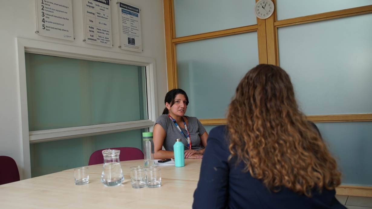 Rebecca Maharaj, a mental health professional with Britain's National Health Service, talks to a high school student in London in this July 4, 2019 file photo. — Thomson Reuters Foundation