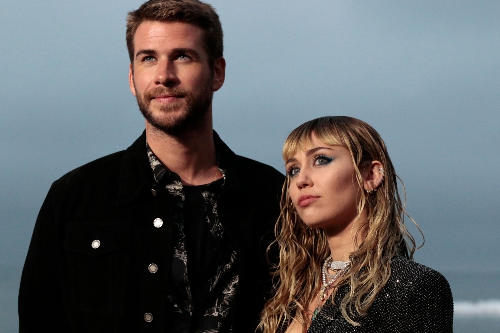 US singer Miley Cyrus and husband Australian actor Liam Hemsworth arrive for the Saint Laurent Men's Spring-Summer 2020 runway show in Malibu, California, in this June 6, 2019 file photo. — AFP