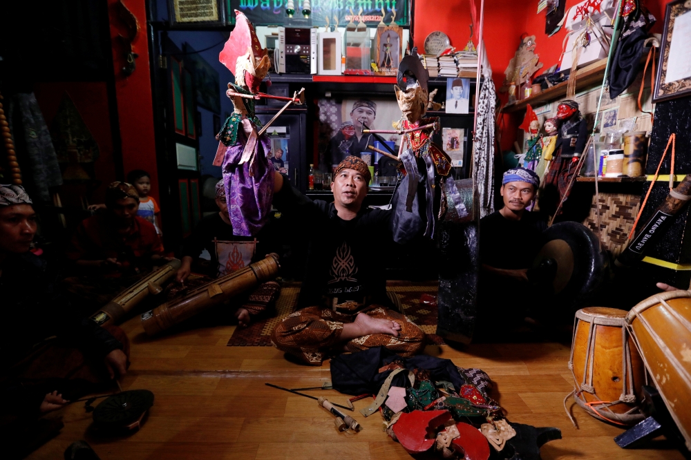 Puppeteer Drajat Iskandar holds bamboo puppets during a training session at his house in Bogor, West Java province, Indonesia, February 24, 2019. -Reuters