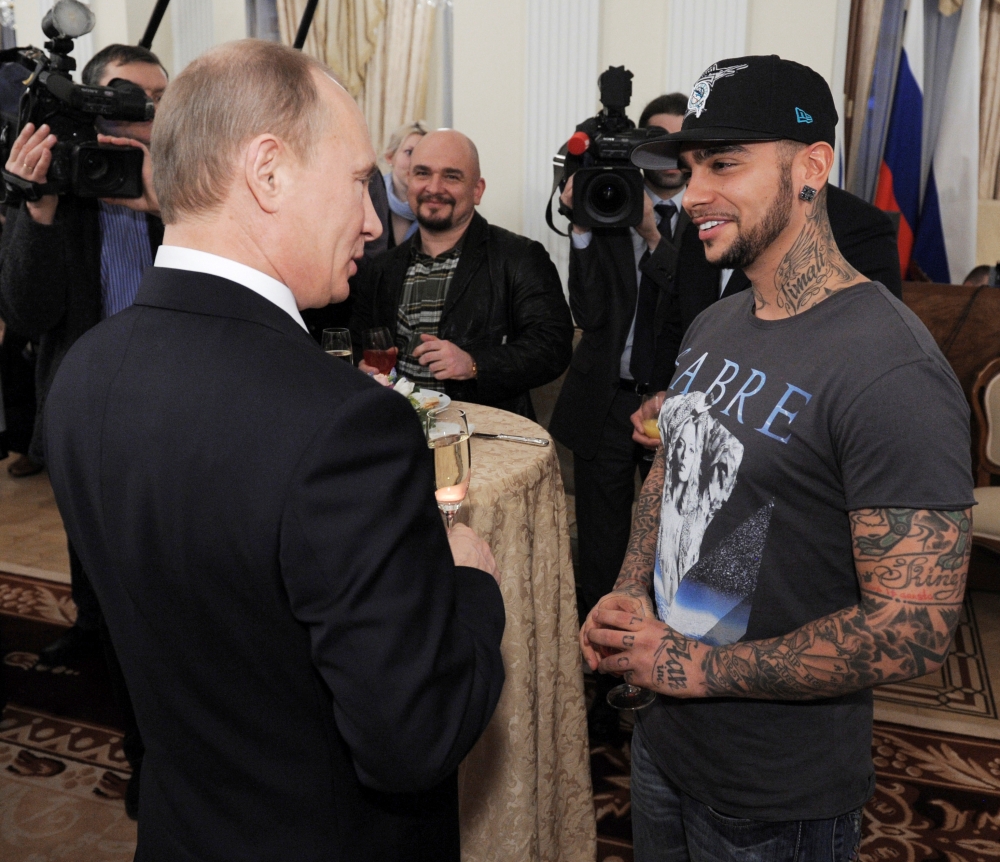 Russian Prime Minister Vladimir Putin, left, talks to rapper Timati during a meeting with his supporters in Moscow in this March 5, 2012 file photo. — Reuters