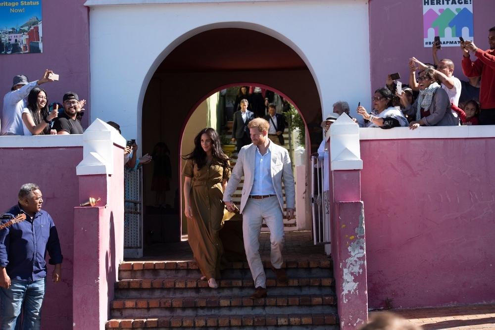Prince Harry, right, Duke of Sussex and Meghan Duchess of Sussex arrive to visit the oldest mosque of Cape Town in Dorp Street in Bo Kaap district on Tuesday. — AFP