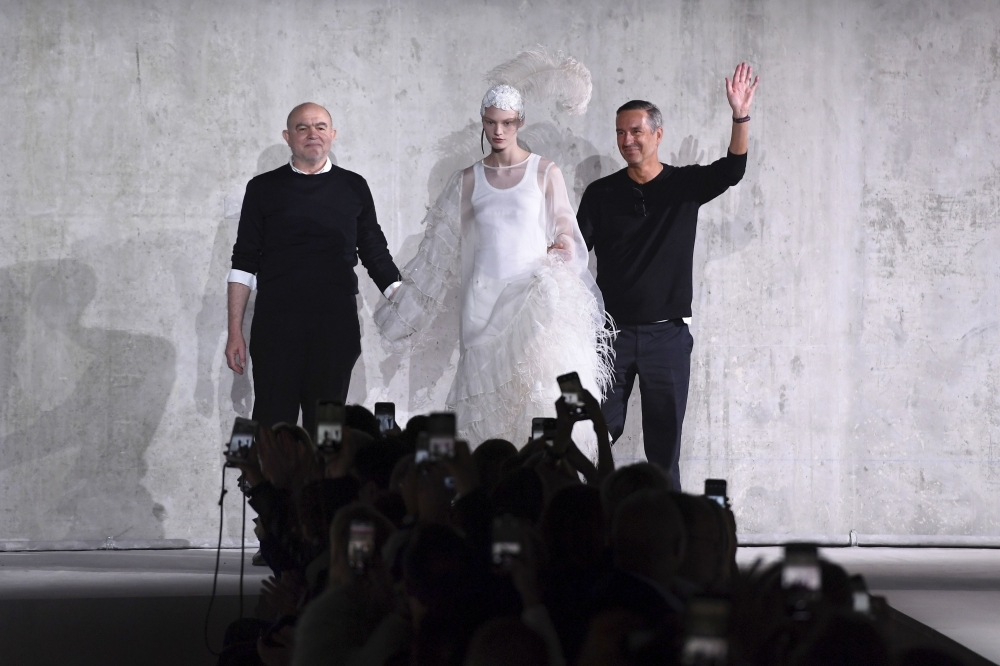 Belgian designer Dries Van Noten, right, and French designer Christian Lacroix acknowledge the audience after the Dries Van Noten fashion show during the Women's Spring-Summer 2020 Ready-to-Wear collection fashion show in Paris, on Wednesday. — AFP