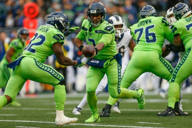 Seattle quarterback Russell Wilson hands off to running back Chris Carson in the Seahawks' 30-29 NFL victory over the Los Angeles Rams. — AFP