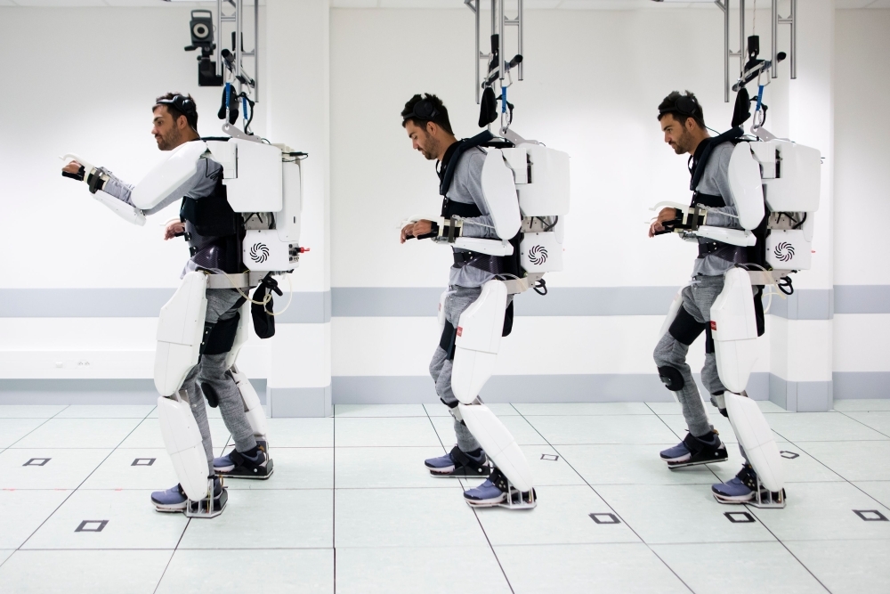 This handout combination of photographs released on Oct. 3, 2019, by Clinatec Endowment Fund (fonds de dotation Clinatec) shows French tetraplegic 'Thibault' as he stands while wearing an exo-skeleton at The University of Grenoble in Grenoble. — AFP
