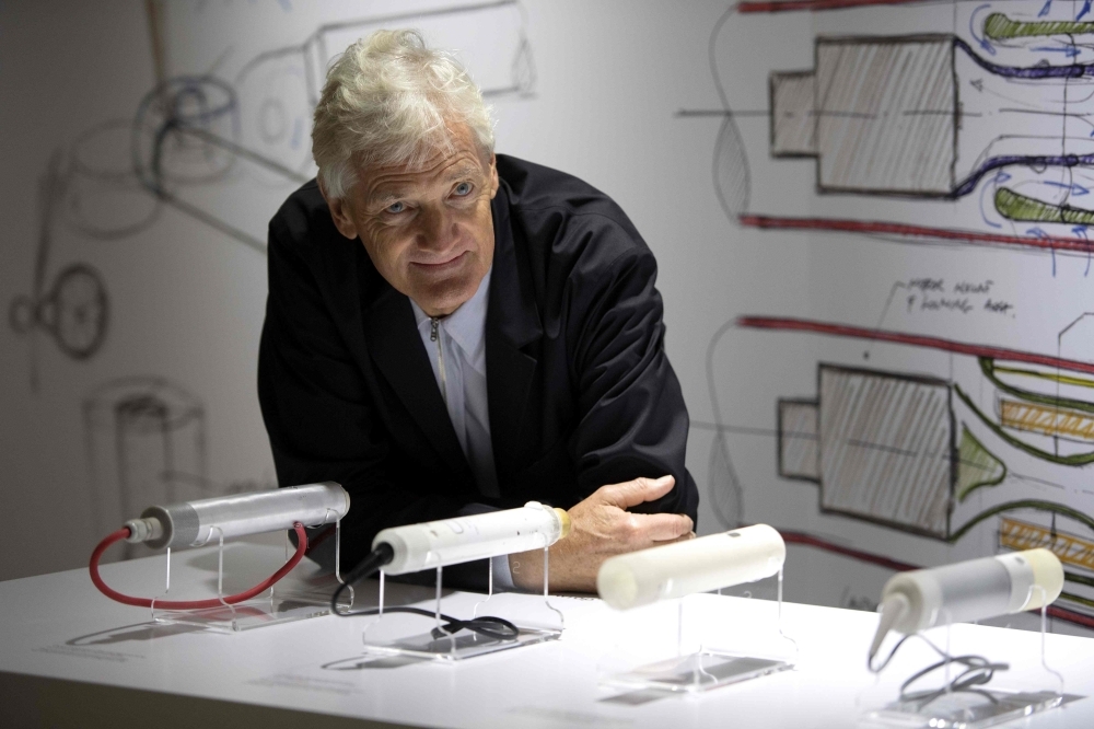 In this file photo taken on Oct. 11, 2018, British industrial design engineer and founder of the Dyson company, James Dyson, poses with products during a photo session at a hotel in Paris. British electric appliance pioneer James Dyson, famed for his vacuum cleaners, announced Thursday that he has abandoned his bid to mass produce electric cars because it was not 