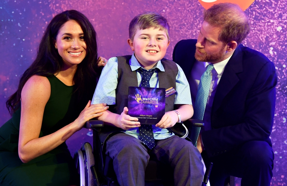 Britain's Prince Harry and Meghan, Duchess of Sussex pose for a photograph with award winner William Magee during the WellChild Awards Ceremony reception in London, Britain, on Tuesday. — Reuters