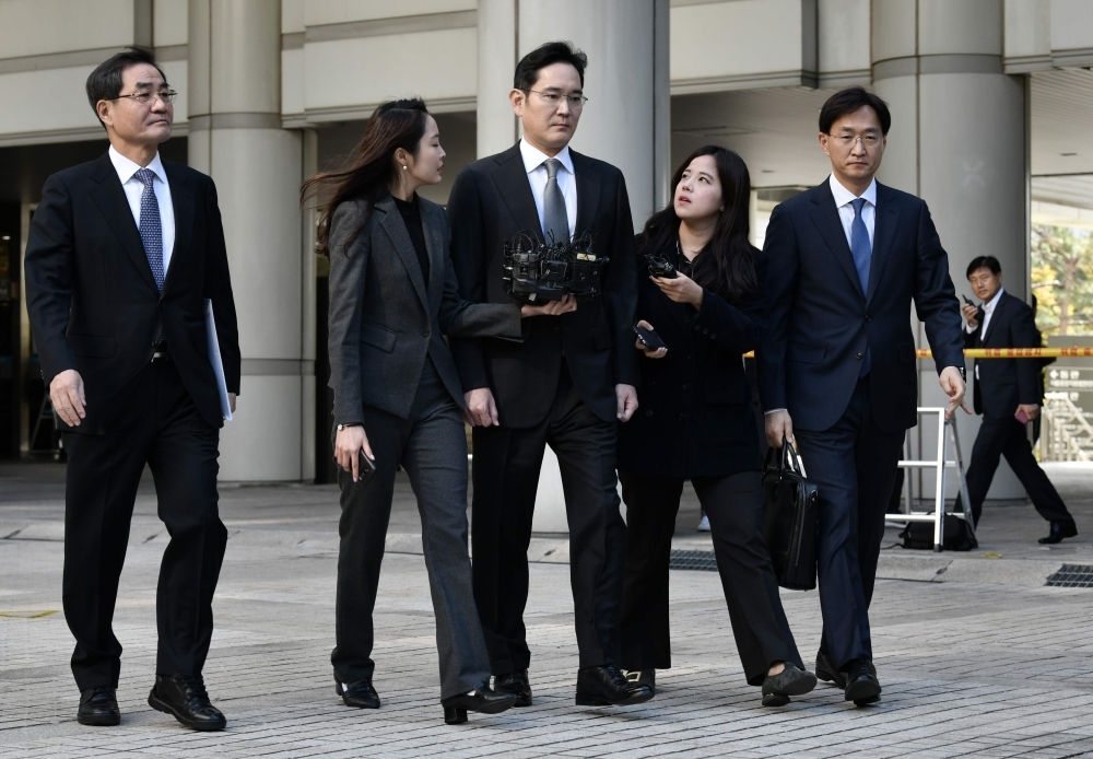 Samsung scion Lee Jae-yong (C), vice chairman of Samsung Electronics, leaves after a retrial at the Seoul High Court in Seoul on Friday. The heir to the Samsung empire appeared in court for a retrial over a sprawling corruption scandal that threatens to disrupt management at the world's biggest smartphone and memory chip maker. — AFP