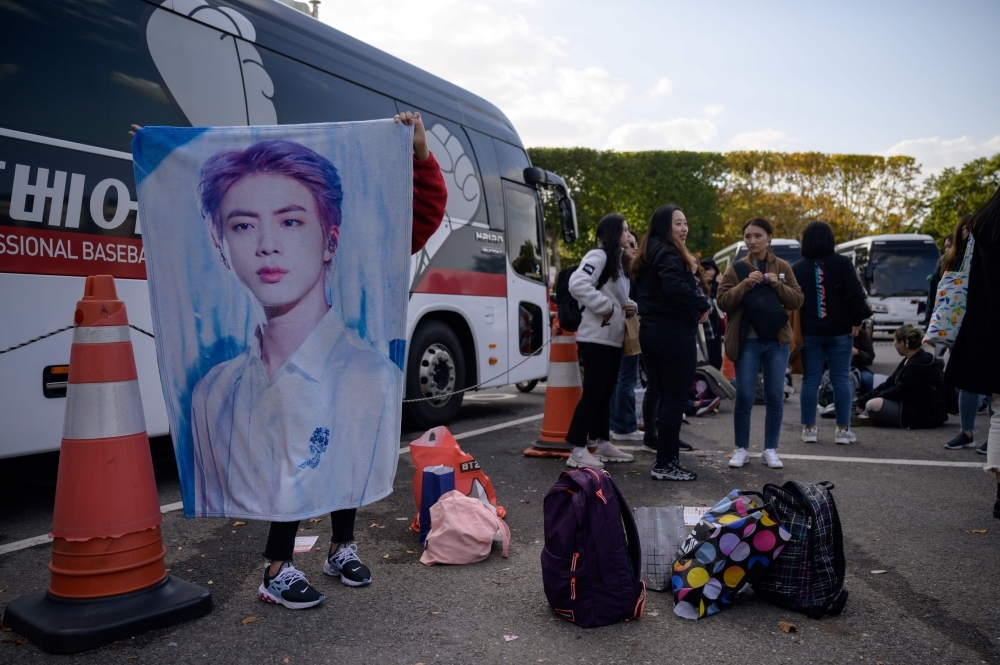A fan of South Korea's BTS K-pop group holds a poster featuring a band member outside the venue for the final concert of their world tour at the Olympic stadium in Seoul in this Oct. 29, 2019 file photo. — AFP