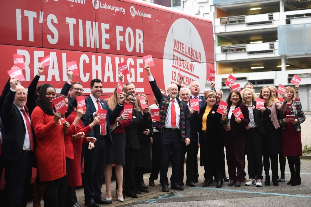 Britain's Labour Party leader Jeremy Corbyn, center, holds up a copy of their general election manifesto with members of his shadow cabinet as he arrives for a manifesto launch event in Birmingham, northwest England, on Thursday. — AFP