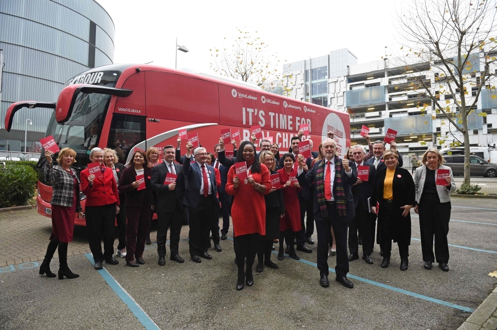Britain's Labour Party leader Jeremy Corbyn, center, holds up a copy of their general election manifesto with members of his shadow cabinet as he arrives for a manifesto launch event in Birmingham, northwest England, on Thursday. — AFP