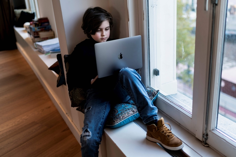 Belgian student Laurent Simons, 9 years old, poses during a photo session at his home in Amsterdam on Thursday. — AFP