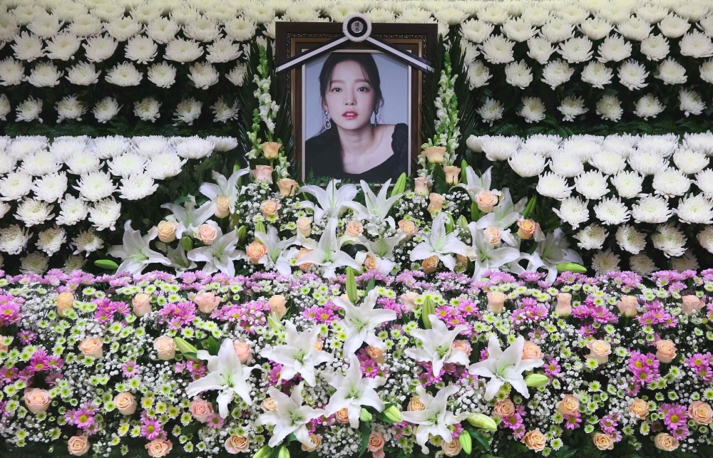 The portrait of late K-pop star Goo Hara is seen surrounded by flowers at a memorial altar at a hospital in Seoul on Monday. — AFP
