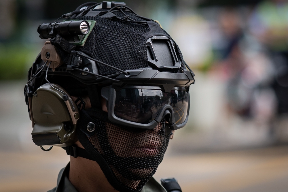 Riot police arrive to disperse people gathering in support of pro-democracy protesters during a lunch break rally in the Kowloon Bay area in Hong Kong on Tuesday. -AFP