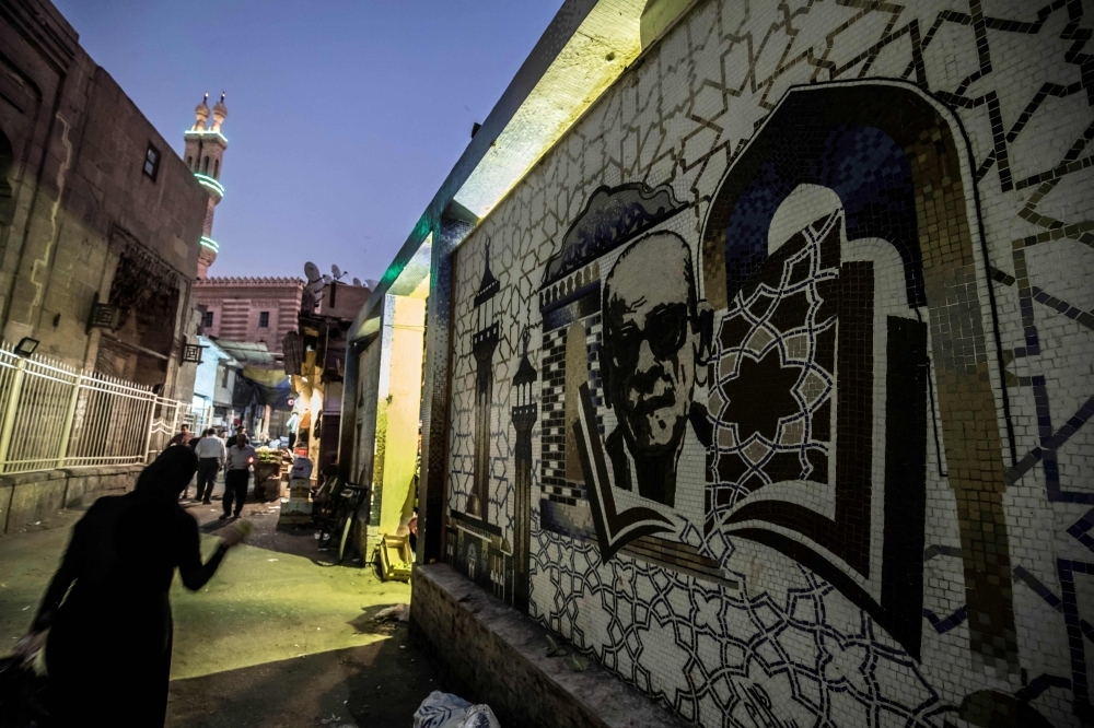 A mural depicting Egyptian novelist and Nobel prize winner Naguib Mahfouz is pictured behind the Al-Azhar mosque in downtown Cairo on Tuesday. — AFP
