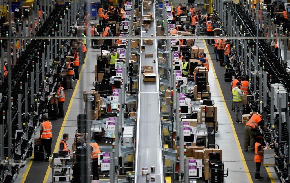 Employees working at the distribution center of US online retail giant Amazon in Dortmund, Germany, in this Nov. 8, 2018 file photo. — AFP