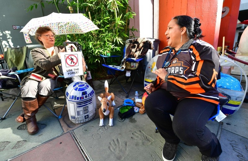 Star Wars fans  Stefanice Vance, left and Veronica Nunez, right, chat while waiting in line outside the TCL Chinese Theater in Hollywood, California, on Friday, where many have been waiting since December 10 over a week in advance of the December 19 opening of the latest Star Wars film 