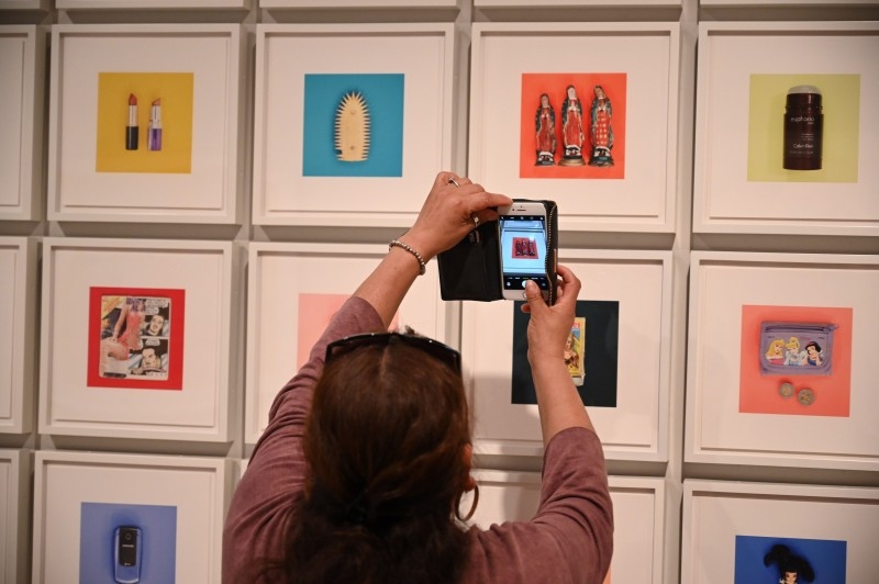 A visitor looks at a photo of cell phones confiscated from migrants at the exhibition 
