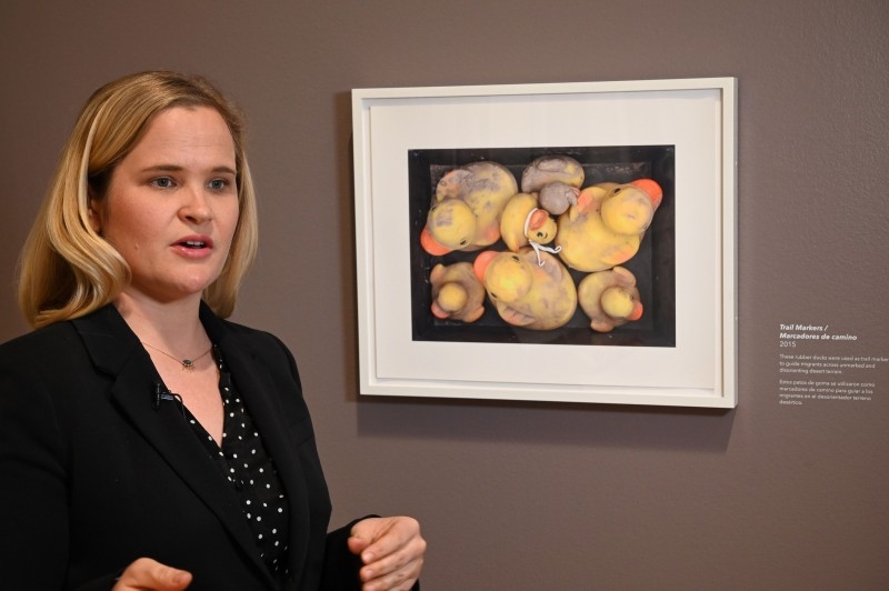 A visitor looks at a photo of cell phones confiscated from migrants at the exhibition 