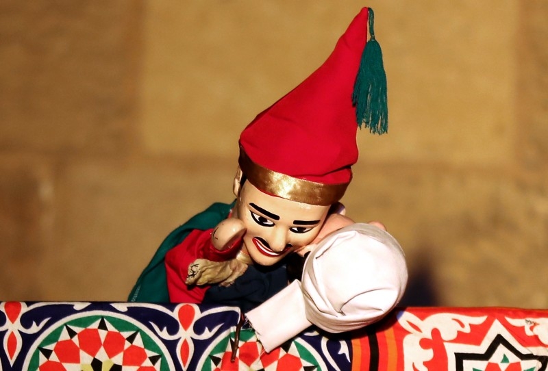 Members of Egypt's Wamda troupe manipulate puppets during a Aragoz puppets show in Beit Al-Sehemi, in Cairo's Gamaliya district, on Nov. 15, 2019. At a historic Islamic Cairo complex, a swarm of spectators scurried for seats to watch Egypt's Aragoz puppet show played by Wamda troupe, the only group striving to save the traditional folk theater.  — AFP