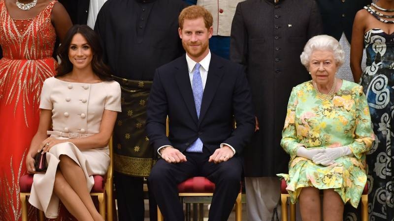 Queen Elizabeth II, right, Prince Harry, center, and his wife Meghan are seen in this file picture. — Courtesy photo